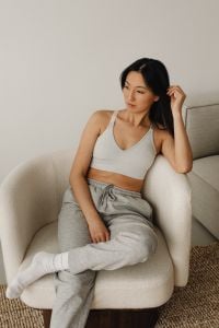 Kaboompics - Woman Touching Her Hair While Sitting on a Cream Sofa at Home