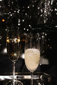 Kaboompics - Champagne Flutes on a Reflective Tray with Silver Tinsel