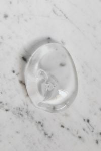 Kaboompics - Transparent Skincare Gel Swirl on White Marble, Minimal Beauty Product Texture Background