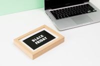 Kaboompics - Black Friday Sign in Wooden Frame beside Laptop on White Desk