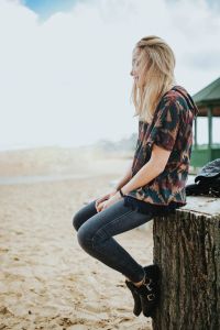 Kaboompics - Woman in Profile on a Beach Stump Facing the Sea