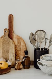 Kaboompics - Kitchen Utensils in a Crock Beside Wooden Cutting Boards and Ceramic Bowls, Vertical Background with Copy Space