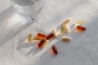 Kaboompics - Amber and Herbal Supplement Capsules on White Linen