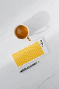 Kaboompics - Top view of a marble desk with coffee, notebooks and pen