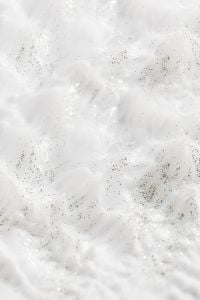 Kaboompics - White Cream Texture with Fine Dark Speckles and Shallow Bubbles, Skincare Macro