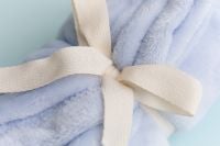 Kaboompics - Close Up Of Soft Blue Blanket With Cream Ribbon