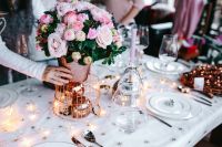 Kaboompics - Hands Arranging Pink Flowers on an Elegant Christmas Table