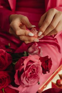 Kaboompics - Close-Up of Hands Opening Chocolate Candy Among Roses