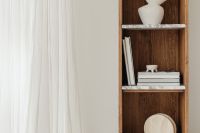 Kaboompics - White Books and a Black Knot Sculpture on a Marble Bookshelf