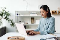 Kaboompics - Asian Woman Working on a Pink Laptop in a Bright Home Office