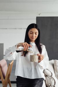 Kaboompics - Woman Pouring Chemex Coffee into a Cup, Side View