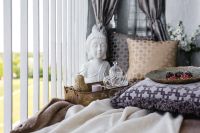 Kaboompics - Relaxing Balcony Tea Setting with Buddha Statue, Decorative Pillows and Berries