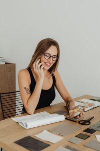 Kaboompics - Woman Talking on Phone at Desk With Samples