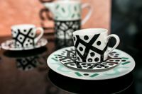 Kaboompics - Graphic Black and White Teacup Set with Mint Accents and Peach Background