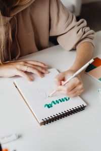 Kaboompics - Designer Sketching on White Paper, Beige Sleeve and Pencil in a Minimal Home Office