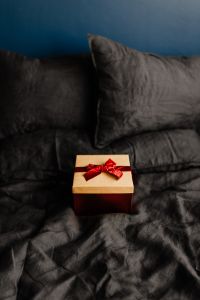 Kaboompics - Black Linen Bedding with a Wrapped Christmas Gift