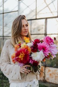 Kaboompics - Woman Holding Dahlia Bouquet In Evening Greenhouse Light