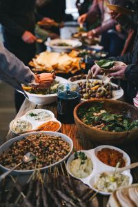 Kaboompics - People by a banquet table full with food