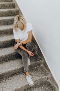Kaboompics - White Sneakers and Gray Jeans on Concrete Stairs, Minimal Casual Outfit Detail