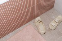 Kaboompics - Beige Bathroom Slippers on Pink Bath Mat