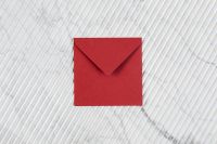Kaboompics - Single Red Envelope on White Ribbed Marble, Minimal Stationery Mockup