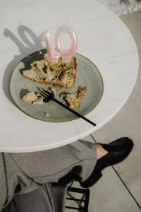 Kaboompics - Cake Slice and Pink Number Candle on a Round Table