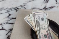 Kaboompics - Overhead Dollar Bills Arranged in a Black Bowl on Marble