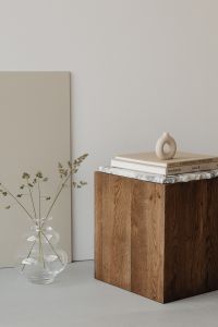 Kaboompics - Minimalist Interior Detail with Walnut Pedestal, Art Books, Ring Vase and Glass Flower Vase