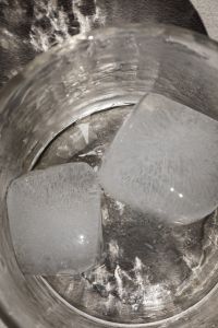 Kaboompics - Close-Up of Clear Ice Cubes Inside a Drinking Glass, Dark Textured Summer Beverage Background