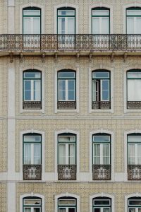 Kaboompics - Ornate Azulejo-Tiled Lisbon Facade with Repeating Windows and Wrought-Iron Balconies