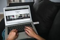 Kaboompics - Rear view of woman using laptop on sofa in the living room