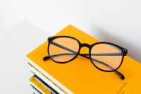 Kaboompics - Close-Up Black Eyeglasses on a Yellow Book Stack