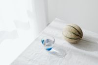 Kaboompics - Overhead Cantaloupe and Water Glass on White Linen, Fresh Summer Beverage Background