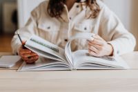 Kaboompics - Woman Turning Pages of Open Book