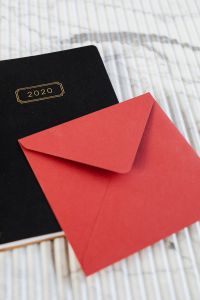 Kaboompics - Close-Up Red Envelope and Black 2020 Planner on Marble, Stationery Flat Lay