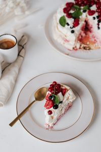 Kaboompics - Vertical Pavlova Slice with Red Currants and Raspberries on White Ceramic