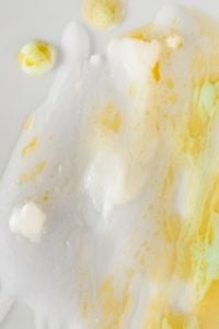 Kaboompics - White Skincare Foam with Yellow Cream Drops on a Pale Background