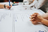 Kaboompics - Hands Writing and Collaborating on a Brainstorming Worksheet