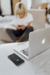 Kaboompics - Laptop-Focused Home Office Scene with Woman Using Her Phone