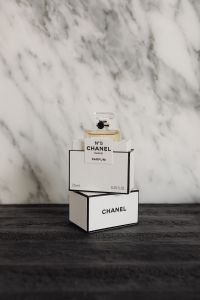 Kaboompics - Chanel No. 5 Perfume in Stacked Boxes on Dark Wood