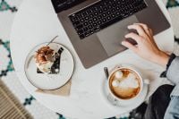 Kaboompics - Working with a laptop, meringue with whipped cream and coffee on white marble
