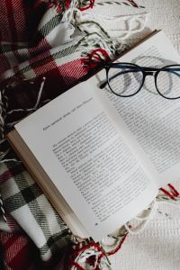 Kaboompics - Open Book With Eyeglasses on Plaid Blanket