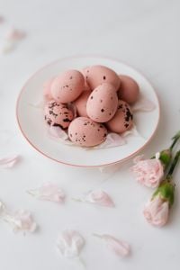 Pink Chocolate Easter Eggs on a White Plate with Spring Flowers and Soft Pastel Styling