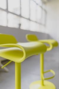 Kaboompics - Vertical Close-Up of Lime Yellow Designer Bar Stool Seats with Soft Window Light