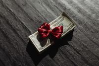 Kaboompics - Cash Gift with Red Ribbon on Dark Background