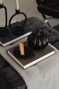 Kaboompics - Black Pumpkin and Candle on Stacked Books