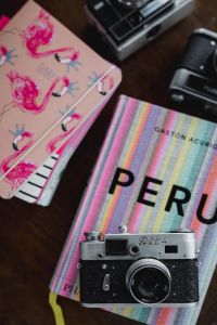 Old analog cameras and pink books on a wooden table