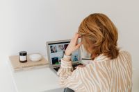 Kaboompics - Woman Working on Laptop beside Books and Candle at Home Desk