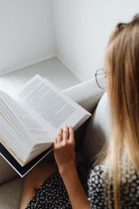 Kaboompics - Woman Reading Large Textbook in Armchair