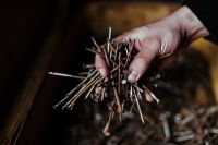Kaboompics - Man grabbing a heap of rusty nails